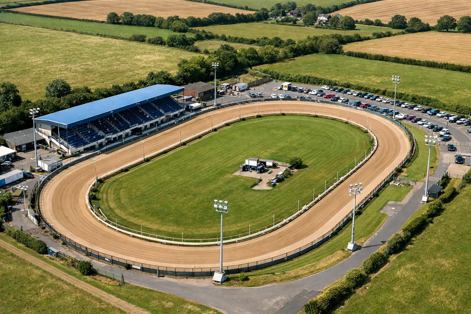 Aerial view of Harlow Greyhound Stadium showing the 334-metre oval track with six starting traps and floodlit grandstand